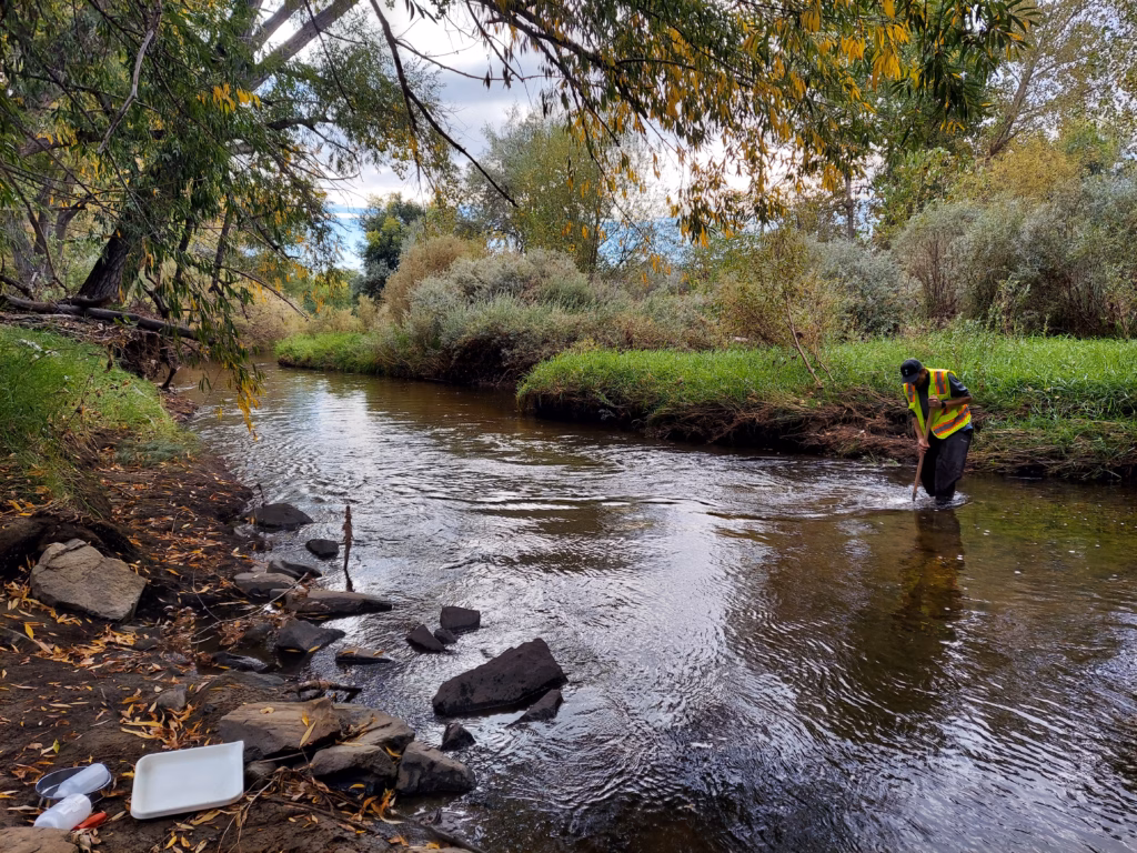 A man collects a sample from a river.