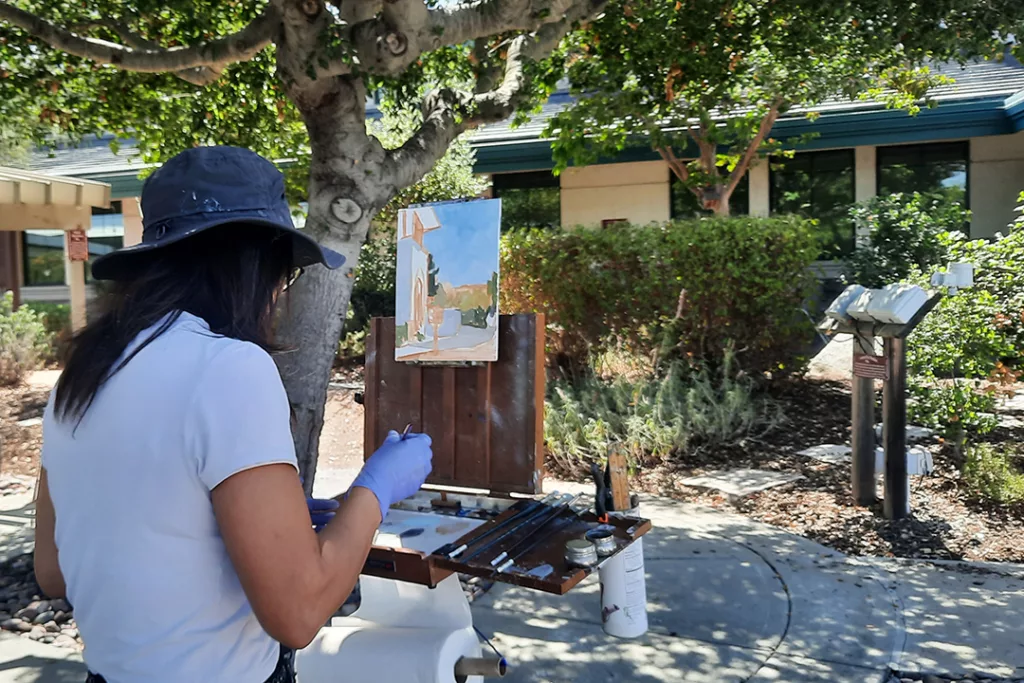 An artist paints a watercolor painting.