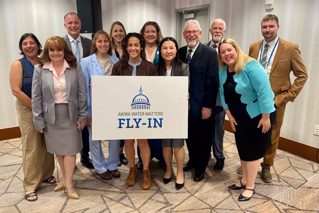 A group of people pose with a sign.