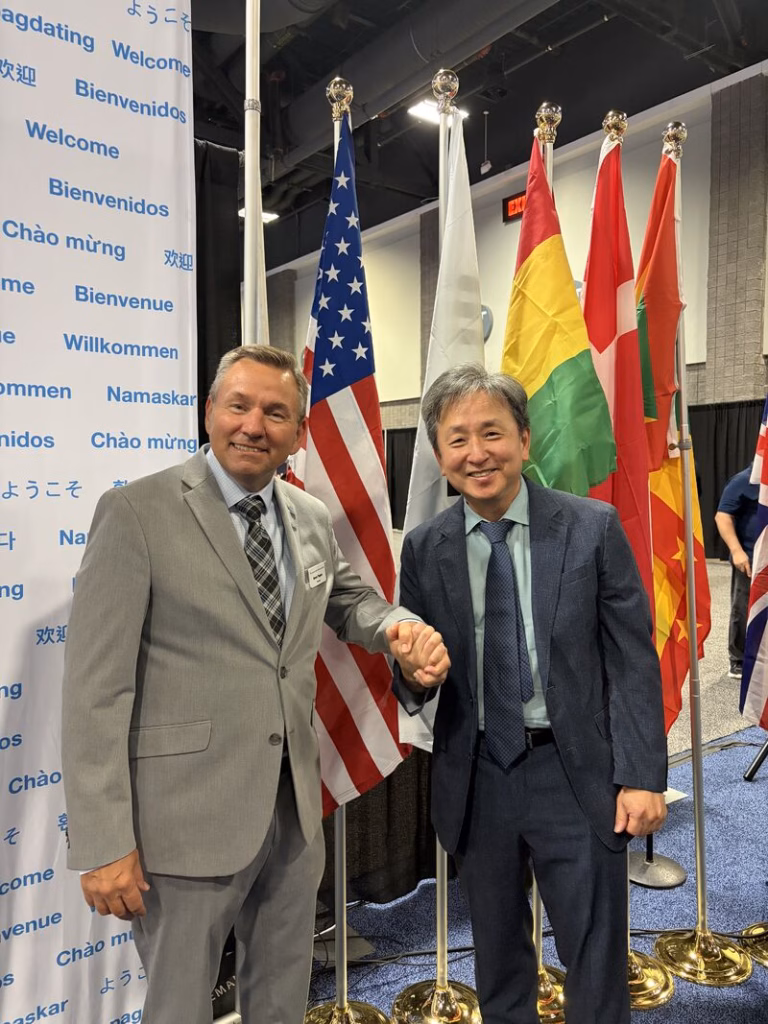 Two men shake hands.
